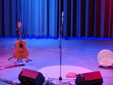 empty stage with a guitar and drum on it